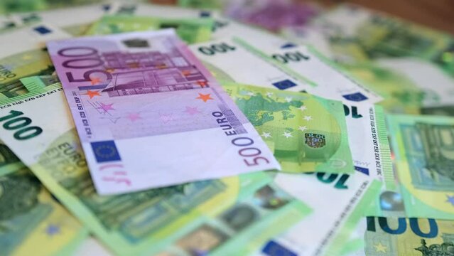 100  and 500 euros bills, close up. Many paper money cash hundreds euro laid on the table revolve. Financial management and budgeting. 