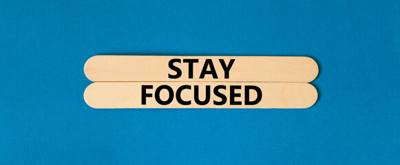 Stay focused symbol. Concept words Stay focused on beautiful wooden stick on a beautiful blue table...