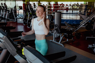 Girl athlete running with headphones in the gym