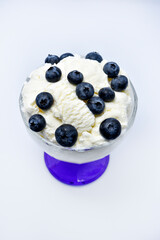 Glass vase with ice cream and blueberries. Blueberry ice cream.
