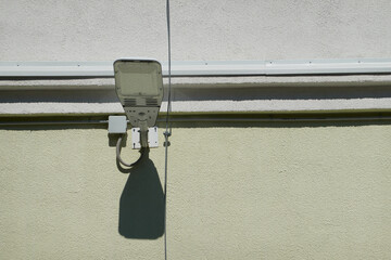 white modern led electric lighting street lamp on city building wall background on clear sunny...