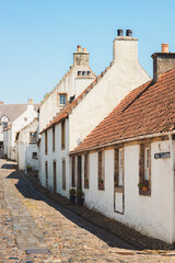 Charming and quaint old town cobblestone lane and white harling cottages in the medieval village of Culross, a popular filming location in Fife, Scotland, UK.