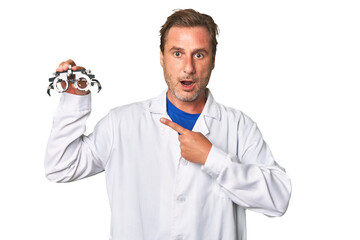 A middle-aged optometrist man pointing to the side