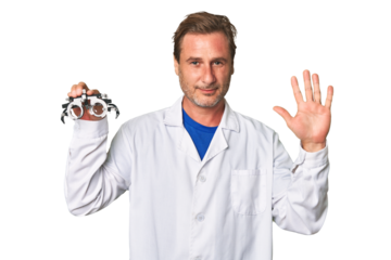 A middle-aged optometrist man smiling cheerful showing number five with fingers.