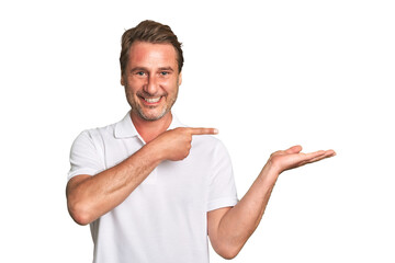 A middle-aged man isolated excited holding a copy space on palm.