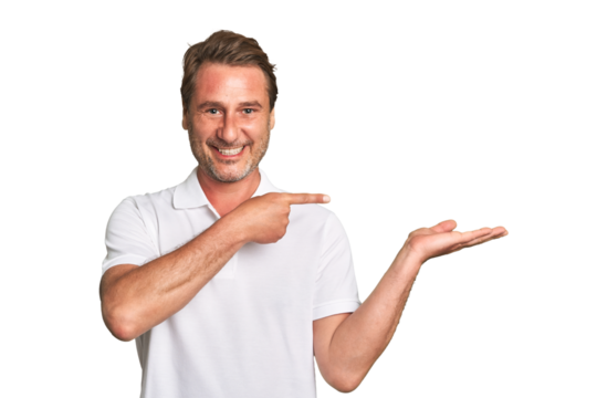A middle-aged man isolated excited holding a copy space on palm.