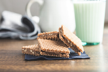 Sweet chocolate wafer on wooden table.
