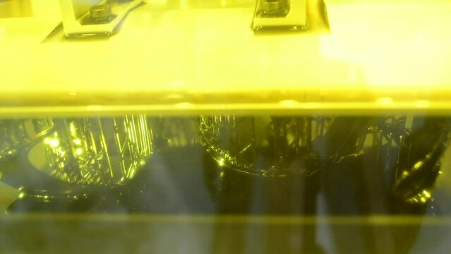 Stereolithography 3d printer. Working process 3d printer from photopolymer resins. 3D printing technology on solidification of liquid material under laser. DPL SLA 3d print UV polymerization close-up