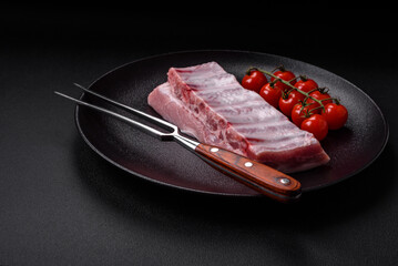 Raw pork ribs with meat with salt, spices and herbs