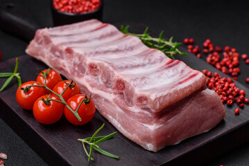 Raw pork ribs with meat with salt, spices and herbs