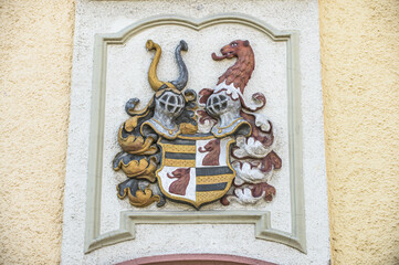 Relief Wappen mit Ritterhelm und Löwenkopf mit Stuckrahmen an Hauswand in Bräunlingen