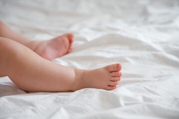 Fototapeta na wymiar The legs of the baby's foot on a white sheet