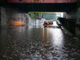 Foto op Aluminium Two cars stranded in flood water under low bridge in Salford city street flashing emergency lights. © Oddpal
