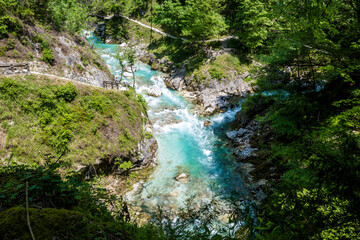 Tourists walking around turquoise Soca river gorges in beautiful mountain landscape of Slovenian Alps