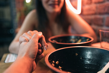 Unrecognizable young couple shaking hands after enjoying a delicious poke bowl together.