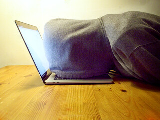 Laptop faceplant, a young man wearing a hoodie, his face on top of a laptop