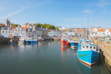 Colourful fishing boats moored at the harbour in the scenic East Neuk seaside village of...