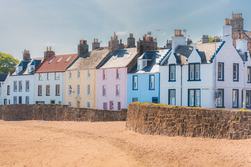 A colourful row of seaside houses on the sandy beach of the quaint coastal fishing village of...