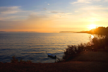 Small fishing boat illuminated by warm golden hour light. Beautiful sunset in Stobrec, small town near Split, Croatia.