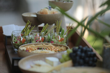 Um lindo prato de cerâmica artesanal exibe uma deliciosa porção de homus de grão de bico, servido em uma mesa de comidas em um refinado evento social.