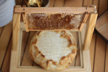 Queijo brie na massa folhada com favo de mel suspenso, uma apresentação criativa e requintada em evento social chique.