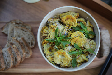Uma linda tigela de cerâmica artesanal repleta de corações de alcachofra, servidos com requinte em um evento social. Uma combinação perfeita de sabores e texturas, preparada com cuidado e capricho.