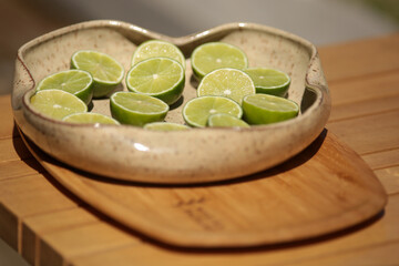 Um prato de cerâmica artesanal exibe uma seleção de limões cortados ao meio, prontos para servir como shots saudáveis, em um evento social chique.