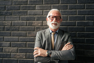 Portrait of one senior man stand on front of brick wall wear suit