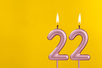 Birthday candle number 22 - Birthday celebration on yellow background