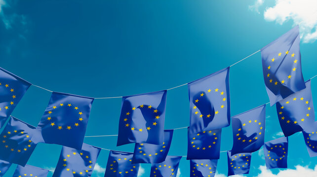 Flag of European Union against the sky, flags hanging vertically