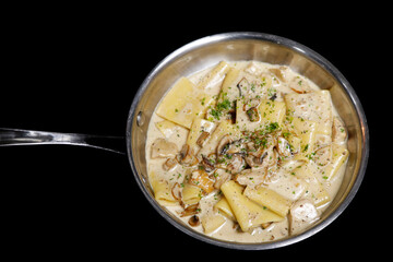 traditional italian creamy wild mushroom pasta with truffle, ceps and porchini, black background