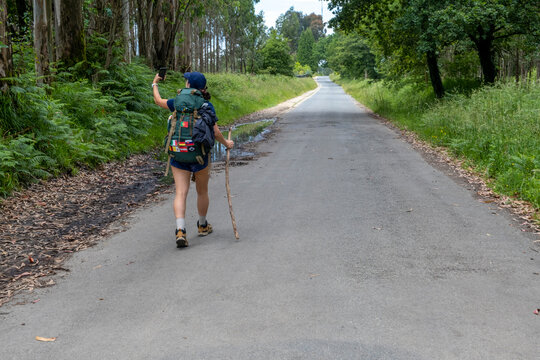 Young woman pilgrim taking a selfie on a trail of the way of saint james. Camino de Santiago