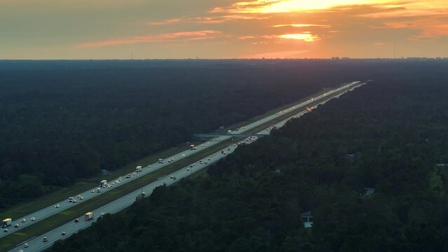High angle view of wide congested american highway with many driving cars and trucks at sunset. Concept of interstate transportation system