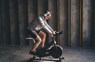 Obraz na płótnie Canvas Man doing exercise on bicycle simulator