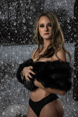 blonde female standing topless in the snow during storm