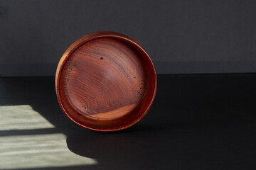 Carved wooden bowl. Dark wood grain dish. Luxury kitchenware.