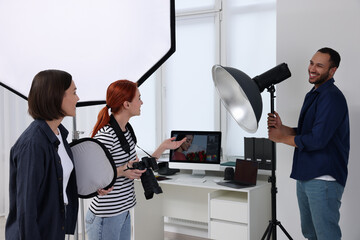 Young professional photographers working in modern photo studio