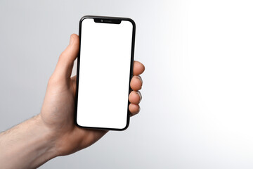 Man holding smartphone with blank screen on white background. Mockup for design