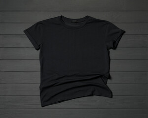 Stylish black T-shirt on gray wooden table, top view
