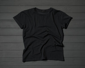 Stylish black T-shirt on gray wooden table, top view