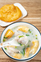 angle view fish porridge with deep-fried Chinese donuts at vertical composition