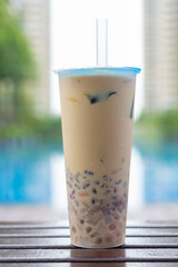 cup of grass jelly near a swimming pool at vertical composition