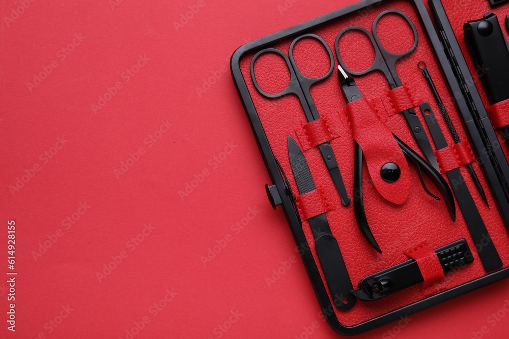 Wall mural Kit of pedicure tools on red background, top view. Space for text