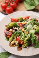 Tasty salad with balsamic vinegar on table, closeup