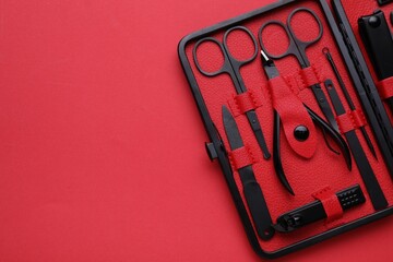 Kit of pedicure tools on red background, top view. Space for text