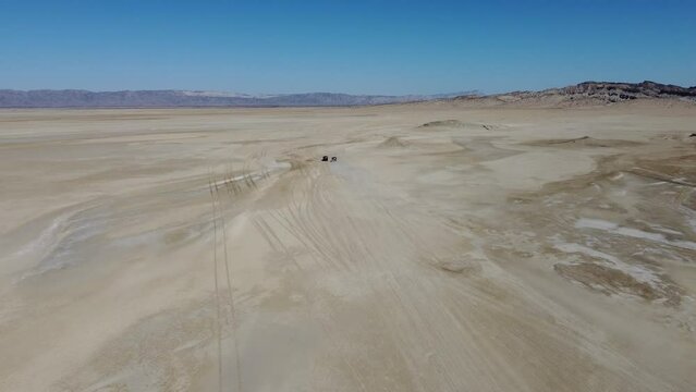 Aerial drone forward moving shot driving along sandy sapat beach, buji koh, Balochistan on a sunny day.