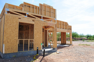 A partial view of a wooden single-family home under construction and its lot