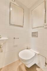 a white toilet in a bathroom with two mirrors on the wall behind it and a sink next to the toilet