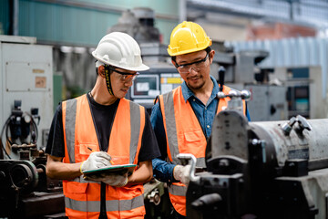 Engineers or Supervisors using a digital tablet and discussing inspection workshops mechanical...