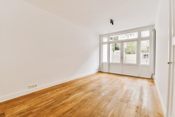 an empty room with wood flooring and white paint on the walls there is a door leading to another room
